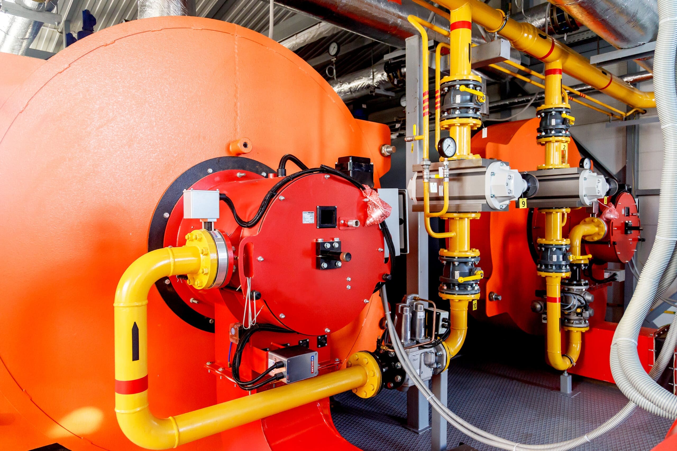 Contemporary industrial powerful water boiler with gas burner and automatic control systems.